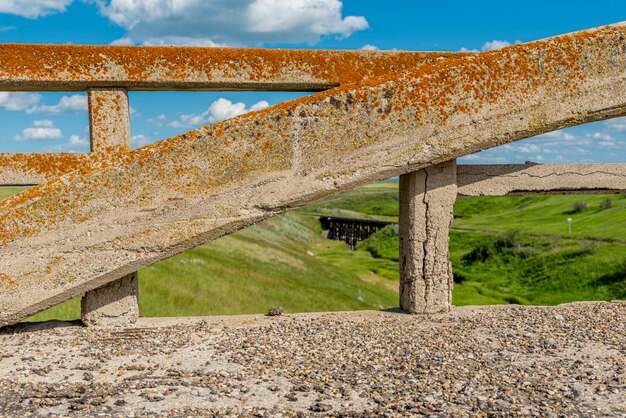 Lichen-covered arch from the concrete bridge in Scotsguard, SK with a historic railway tressle in the background