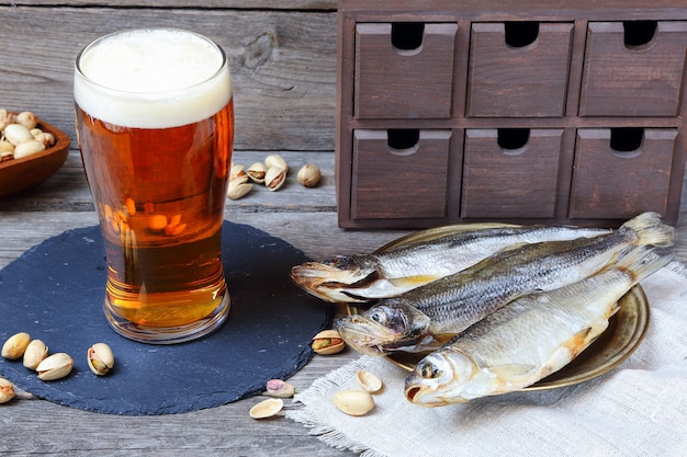 Licht bier en stokvis - smelt en vobla, traditionele Russische biersnack, op een houten grijze tafel