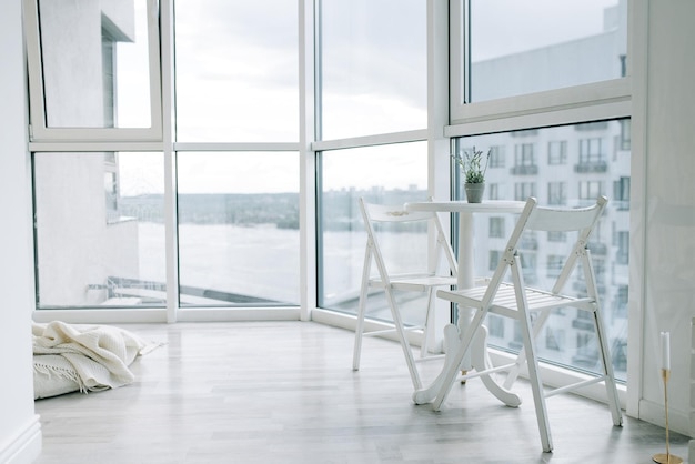 Licht en ruim appartement op de bovenste verdieping met grote ramen Tafel en stoelen bij het raam