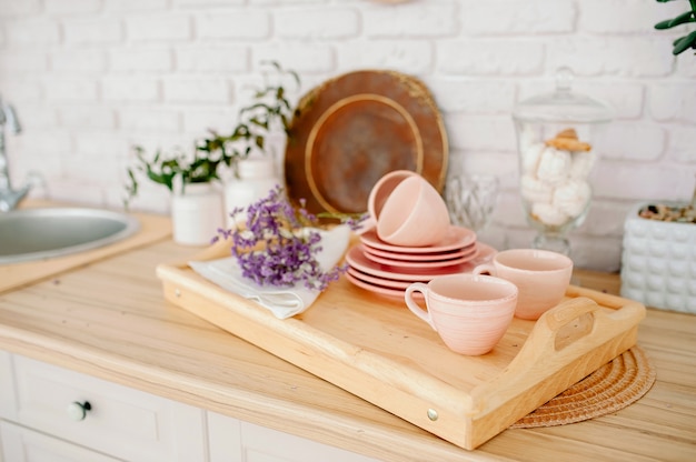 Licht houten keukenbinnenland. mooi keukeninterieur. lichtroze servies borden bekers