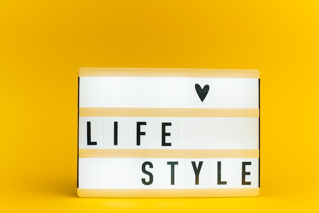 lichtbak met tekst, LIFE STYLE, op gele muur