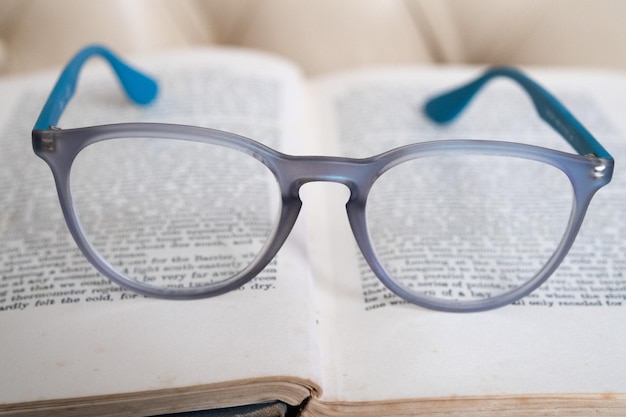 Lichtblauwe leesbril geïsoleerd op een boek