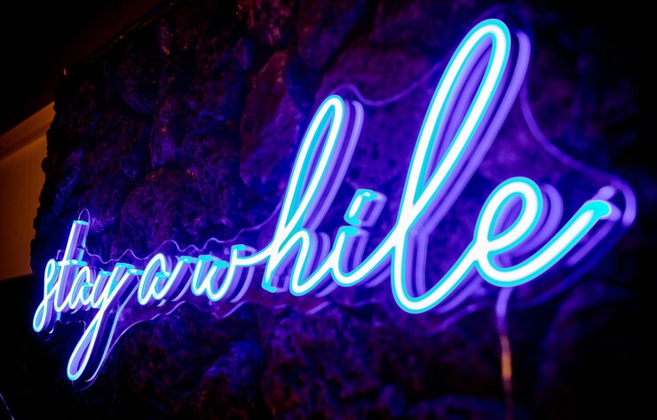 Foto lichtblauwe neon lamp teken met de woorden blijven een tijdje