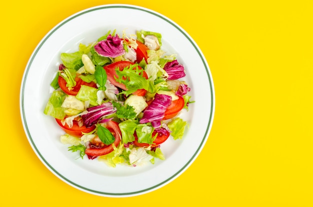 Lichte dieet vegetarische salade in plaat op gele tafel