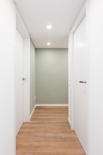 Lichte gang met ingangen naar kamers met deuren en draaien naar het juiste concept van renovatie en