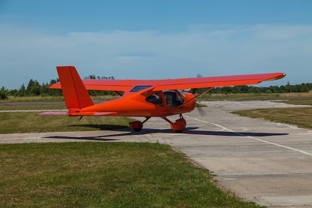 Lichte vliegtuigen van een rode kleur op een privé vliegveld om voor de vlucht voor te bereiden