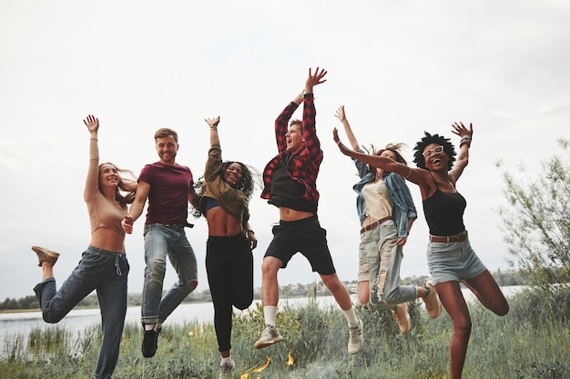 Lichte zomerkleding. Groep mensen hebben picknick op het strand. Vrienden hebben plezier in het weekend.