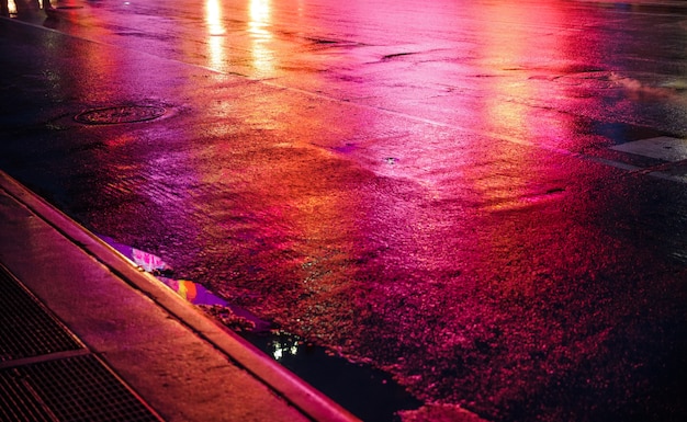 Lichten en schaduwen van New York City. NYC straten na regen met reflecties op nat asfalt. Silhouetten van mensen die op straat lopen