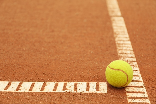 Lichtgroene tennisbal op gravel