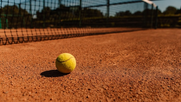 Lichtoranje leeg buitenkleibaanoppervlak droog grungy grondbasislijndetail voor tennissen