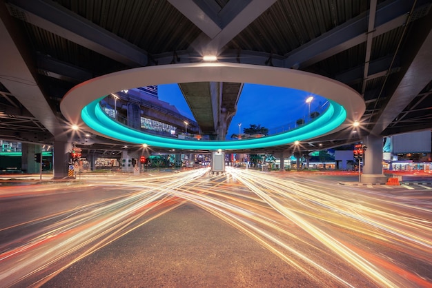 Lichtpaden op een snelweg met meerdere rijstroken onder een verhoogde weg in de stad's nachts