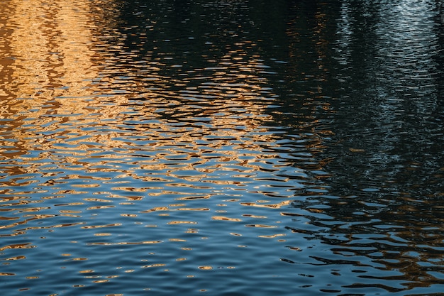 Lichtreflecties op de kleine watergolven van een stedelijke vijver