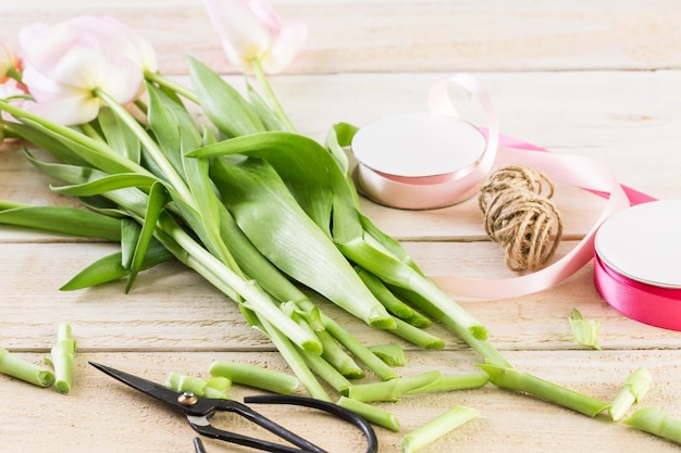 Lichtroze tulpen op een houten ondergrond.