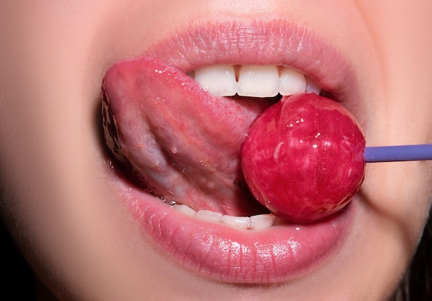 Licking tongue lips sexy woman mouth with pink lips holding lollipop beauty closeup sexy girl suck l