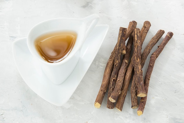 Licorice tea and roots on white background
