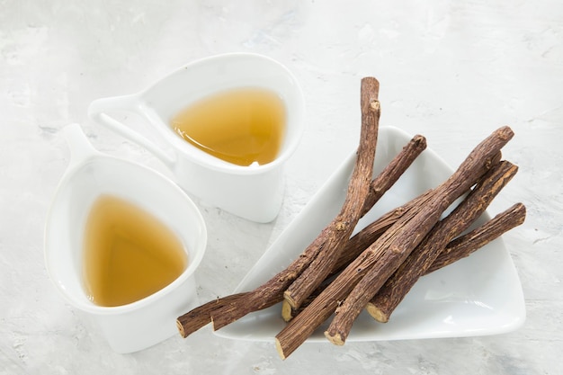 Licorice tea and roots on white background