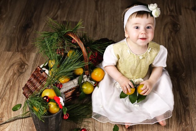 Lief klein meisje in jurk met kerstmand