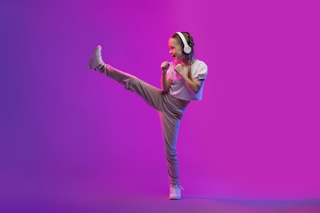 Lief preteen kindmeisje dat draadloze hoofdtelefoons gebruikt en karate doet