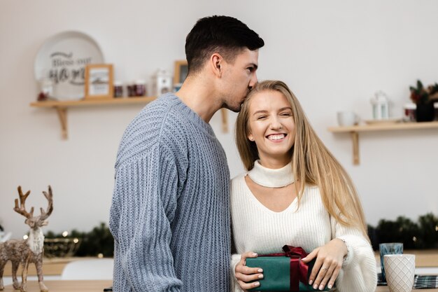 Lief stel dat kerstcadeaus opent in de woonkamer thuis