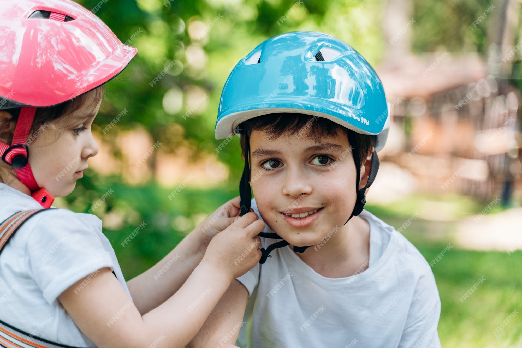 Storing Basistheorie circulatie Lief zusje helpt haar broer om zijn beschermende helm vast te maken.  kinderen hebben plezier buiten | Premium Foto