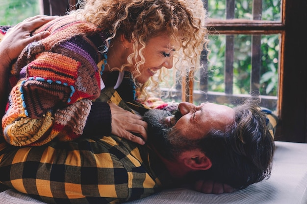 Liefde en tederheid met passie voor volwassen volwassen koppels die thuis op de grond liggen en genieten van een relatie. Jonge volwassen man en vrouw mensen lachen en hebben samen plezier