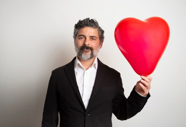 Liefde en valentijnsdag man met hart lachend schattig en schattig geïsoleerd. valentine man met rode luchtballon.