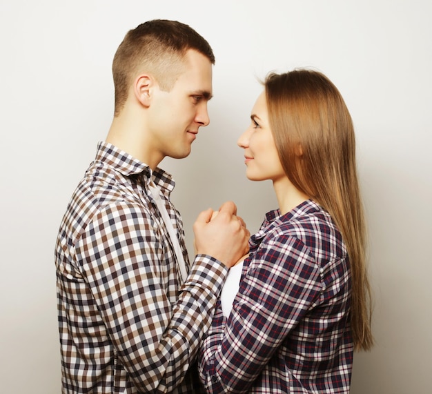 Liefde familie en mensen concept liefelijk gelukkig paar omhelzen over grijze achtergrond