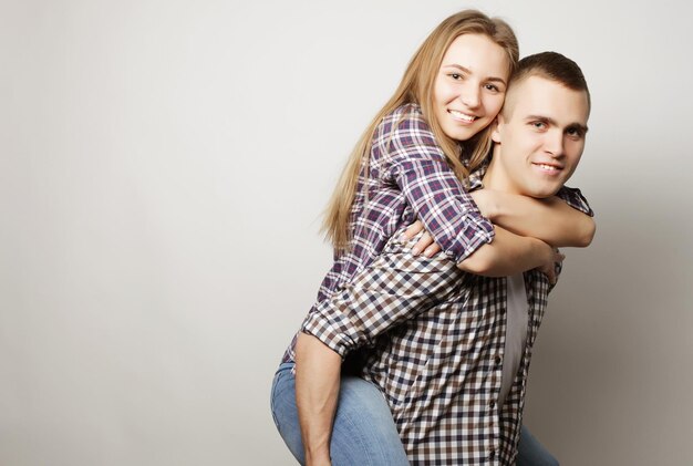 Liefde familie en mensen concept liefelijk stel jonge man draagt vriendin op zijn rug
