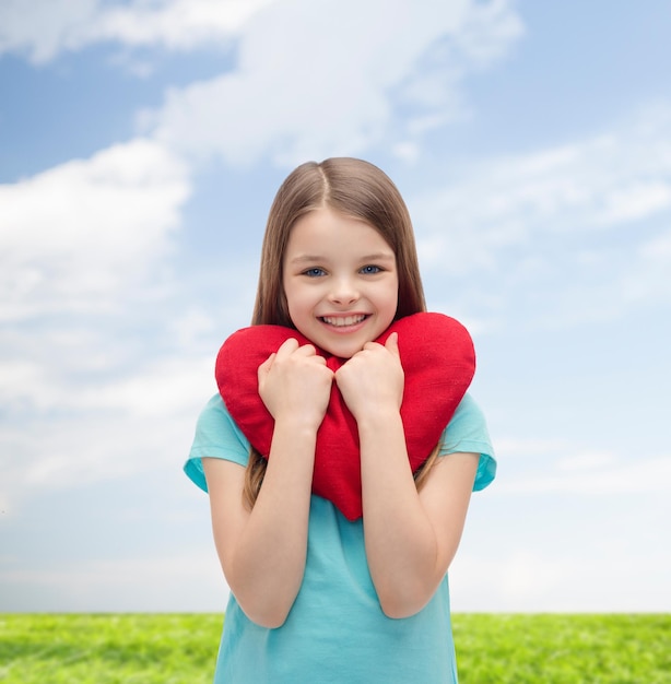 liefde, geluk en mensenconcept - glimlachend meisje met rood hart