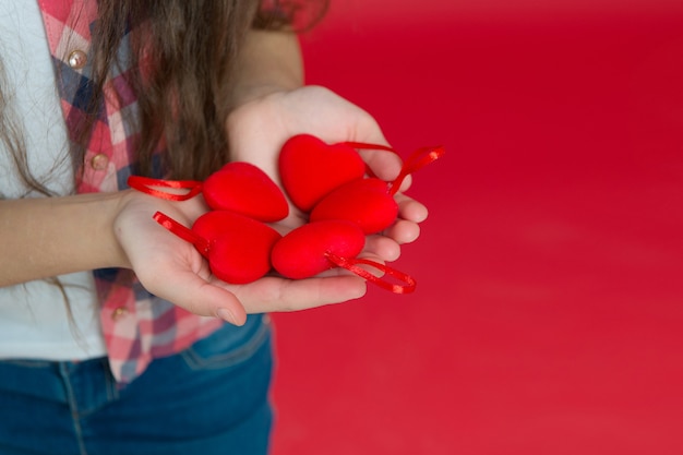 Liefde is een geweldig gevoel. Valentijnsdag. Klein meisje met harten in handen. gelukkig klein meisje. Liefde en familie. Jeugd geluk. Februari vakantie. Kinderdag. Gelukkig kind met hart. ruimte kopiëren.