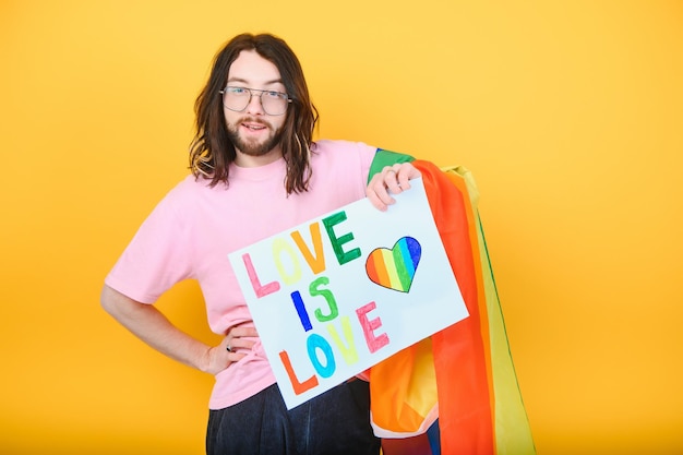 Liefde is liefde Aantrekkelijke blanke homoseksuele man die een protestbord vasthoudt tijdens een LGBT-prideparade