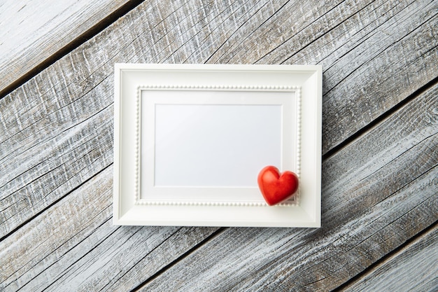 Foto liefde valentijnsdag concept leeg afbeeldingsframe en rood hart top uitzicht