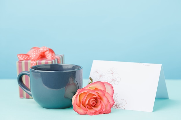 Liefdesachtergrond met roze rozen, bloemen, cadeau op tafel