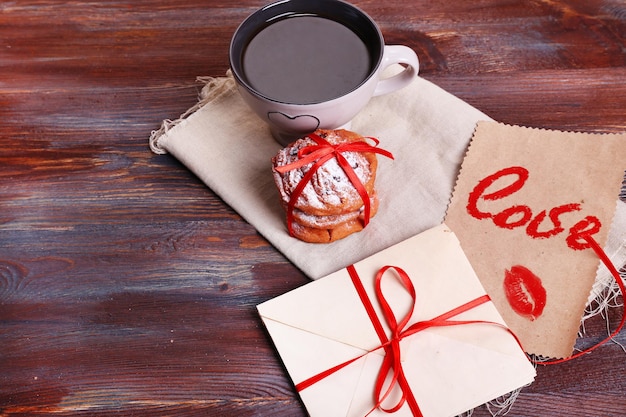 Liefdesbrieven met koffie en koekjes op houten achtergrond