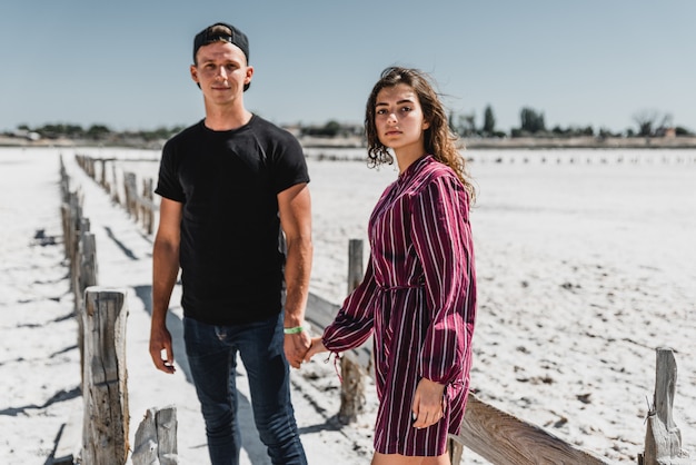 Liefdesverhaal in de woestijn, gelukkig jong stel, jonge mensen lopen en hand in hand, zomervakantie voor een jong stel