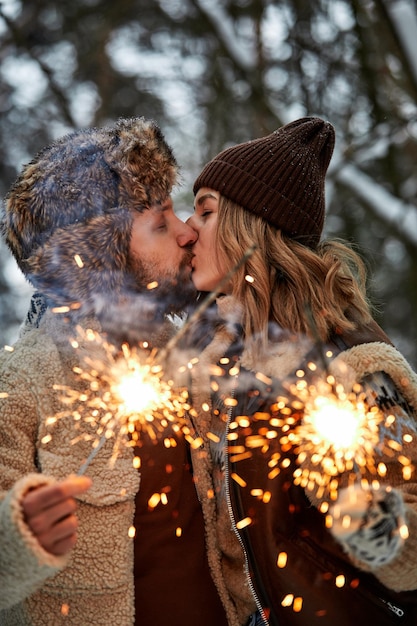 Liefdesverhaal van een paar in het sneeuwbos dat sterretjes kust en vasthoudt paar in de natuur van de winter dat valentijnsdag viert