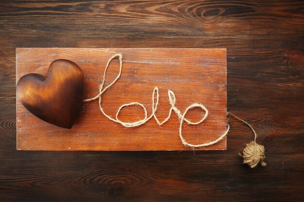 Liefdeswoord en bruin hart op houten tafel