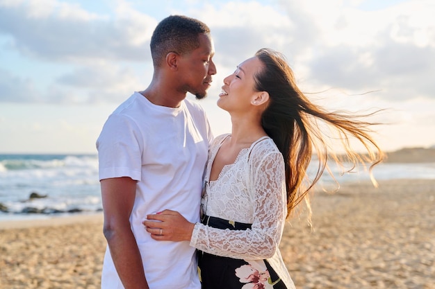 Liefdevol romantisch knuffelend jong stel aan de kust