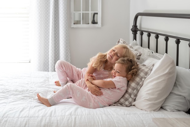 Foto liefdevolle broers en zussen liggen thuis op bed.