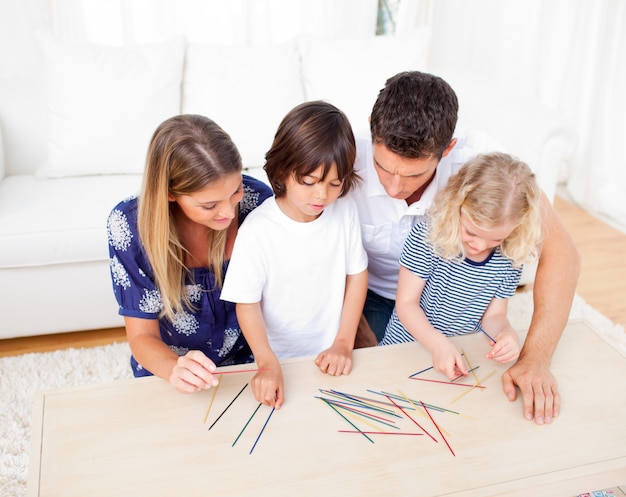 Liefdevolle familie mikado spelen in de woonkamer