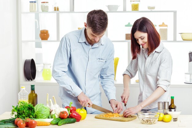 Liefdevolle gelukkige paar voorbereiding van een gezonde salade van verse groenten in de keuken