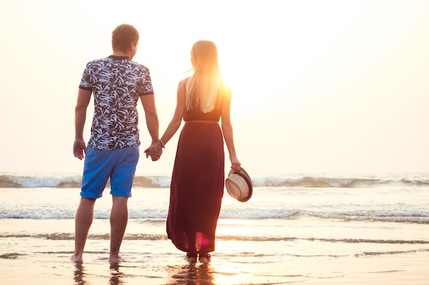 Liefdevolle gelukkige paar wandelen langs het strand. Romantische vakantie gelukkige huwelijksreis.