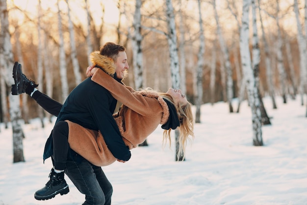 Liefdevolle jong koppel wandelen spelen en plezier hebben in winter forest park