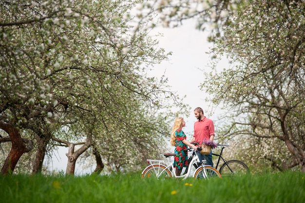 Liefdevolle jong stel met fietsen in de lentetuin