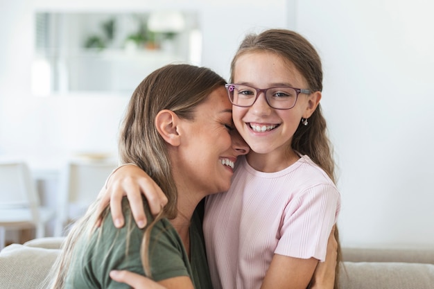 Liefdevolle jonge moeder lachen omarmen lachende schattige grappige kind dochter genieten van tijd samen thuis, gelukkige familie alleenstaande moeder met klein kind meisje plezier spelen voel vreugde knuffelen en knuffelen