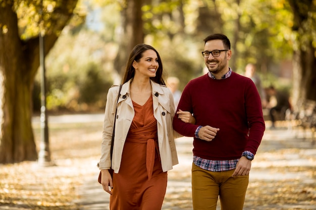 Liefdevolle jonge vrouw en man wandelen in stadspark hand in hand