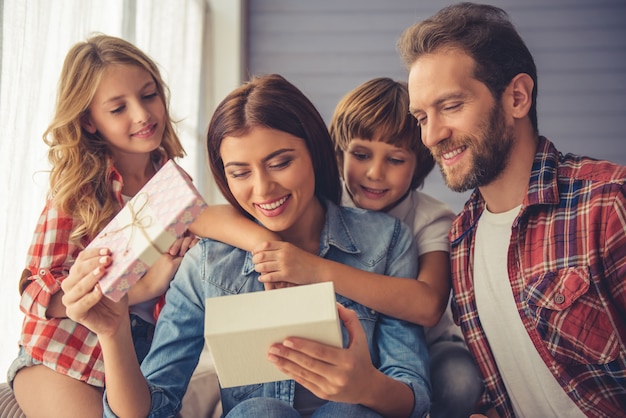 Liefdevolle kinderen en echtgenoot geven een cadeau.