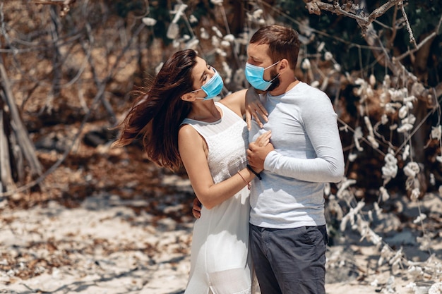 Liefdevolle romantisch verliefde paar dragen van een beschermend gezichtsmasker en staren naar elkaars ogen, pandemie en gevoelens concept. covid-19-concept.
