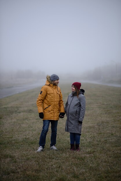 Liefdevolle zwangere paar lopen buiten de stad in de late herfst.