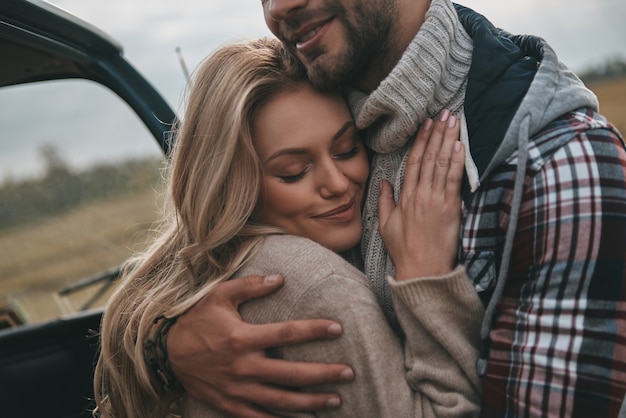 Liefhebbend stel. Mooie jonge paar omarmen en glimlachen terwijl buitenshuis staan